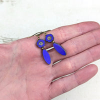 Blue Czech Glass Flower Bead Earrings with Metallic Finish and Antiqued Brass. Photographed in a hand for scale.