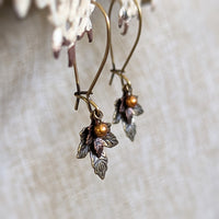 handmade earrings with antiqued bronze and antiqued copper maple leaf charms with a crystal copper pearl dangle.
