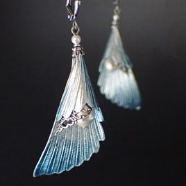 Iridescent Blue and Silver Angel Wing Earrings on a black background