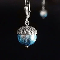 Ethereal silver and blue acorns. The glass beads are silver when viewed head on with a blue iridescence around the edges.