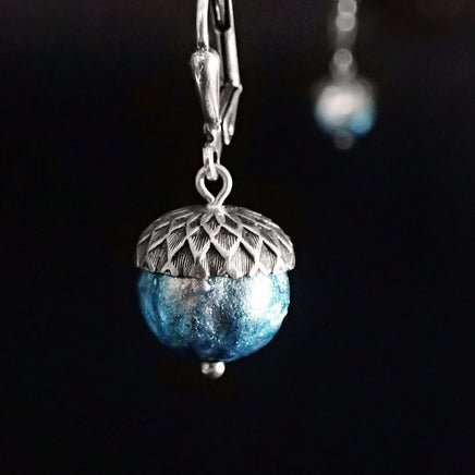 Ethereal silver and blue acorns. The glass beads are silver when viewed head on with a blue iridescence around the edges.
