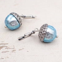 Ethereal silver and blue acorns. The glass beads are silver when viewed head on with a blue iridescence around the edges.