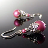 Vivid pink crystal pearls dressed with antiqued silver-colored adornments.